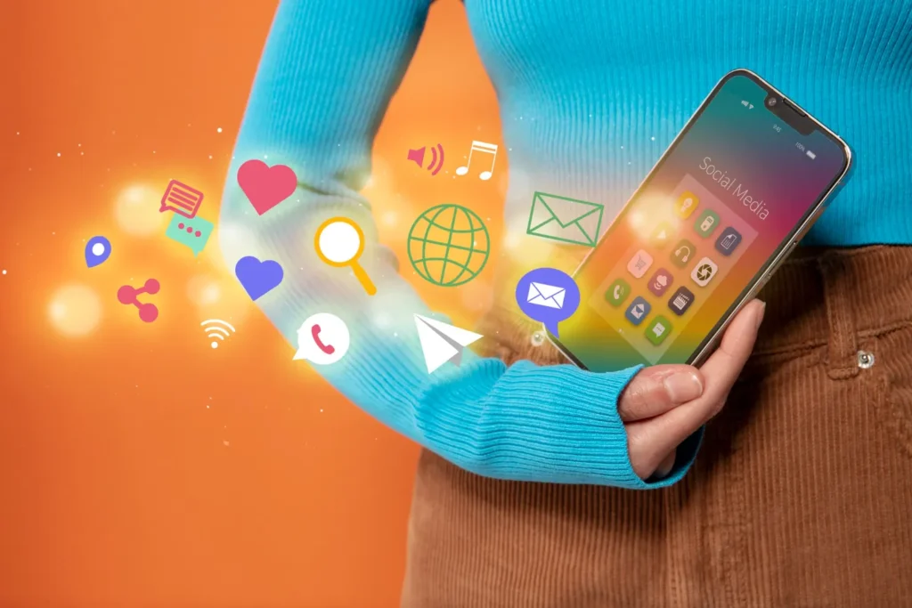 Pessoa segurando um smartphone com ícones de redes sociais, mensagens e notificações flutuando na tela, com símbolos de comunicação e marketing digital ao fundo em cores vibrantes. Publicidade digital: Como criar campanhas que geram atenção e resultados